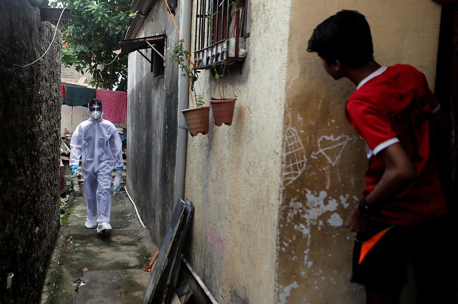 A healthcare worker wearing personal protective equipment (PPE) walks in an alley of a slum area during a check-up camp for the coronavirus disease (COVID-19) in Mumbai, India June 27, 2020. (REUTERS)