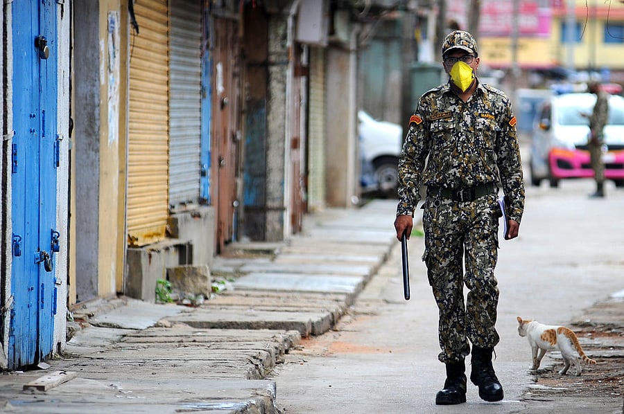 A BBMP marshal surveys the KR Market in Bengaluru on Sunday after the area was sealed down due to rising Covid-19 cases. DH Photo/Pushkar V