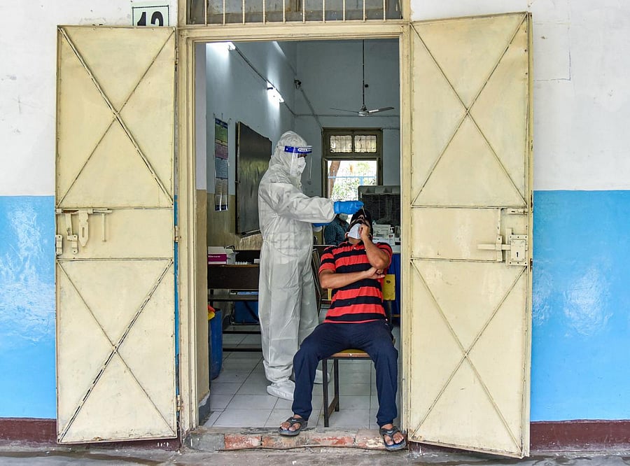 A medic conducts Covid-19 rapid antigen testing of a man at SGTB Khalsa School, in New Delhi, Monday, June 29, 2020. Credit/PTI Photo