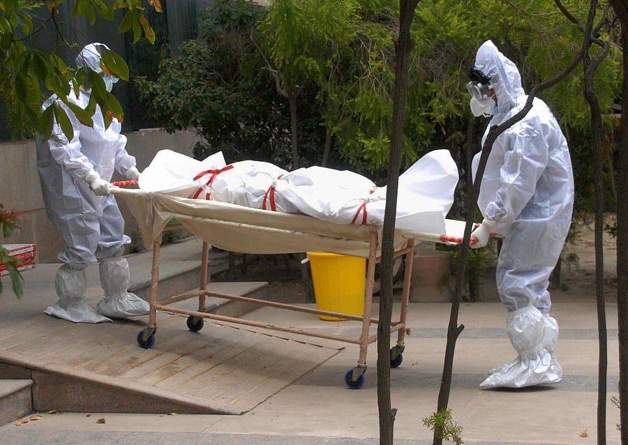 Noida: Medics wearing PPE kits carry the body of a person who died of COVID-19 at a district hospital, in Noida, Friday, June 26, 2020. (PTI Photo)(PTI26-06-2020_000132A)