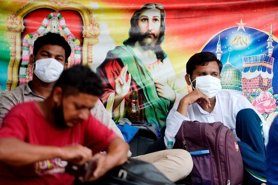 Stranded migrant workers with their belongings wait to board a special train to Bihar state from MGR central railway station after the government eased a nationwide lockdown imposed as a preventive measure against the Covid-19. Credits: AFP Photo