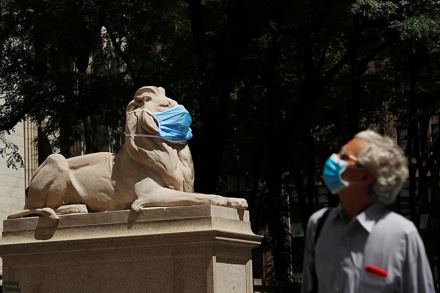 A large mask hangs on the face of a lion statue standing outside of the main branch of the New York Public Library in the Manhattan borough of New York City. Credit/Reuters Photo