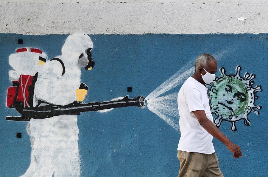A man walks next to a graffiti depciting a cleaner wearing protective gear spraying viruses with the face of Brazil's President Jair Bolsonaro amid the coronavirus disease (COVID-19) outbreak, in Rio de Janeiro, Brazil. Credit: REUTERS
