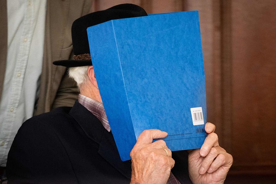 Bruno Dey, a former SS-watchman at the Stutthof concentration camp, hides his face behind a folder before a hearing in his trial on July 6, 2020 in Hamburg, northern Germany. Credit: AFP Photo