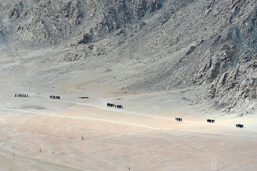 Indian soldiers walk at the foothills of a mountain range near Leh, the joint capital of the union territory of Ladakh. Credit: AFP Photo