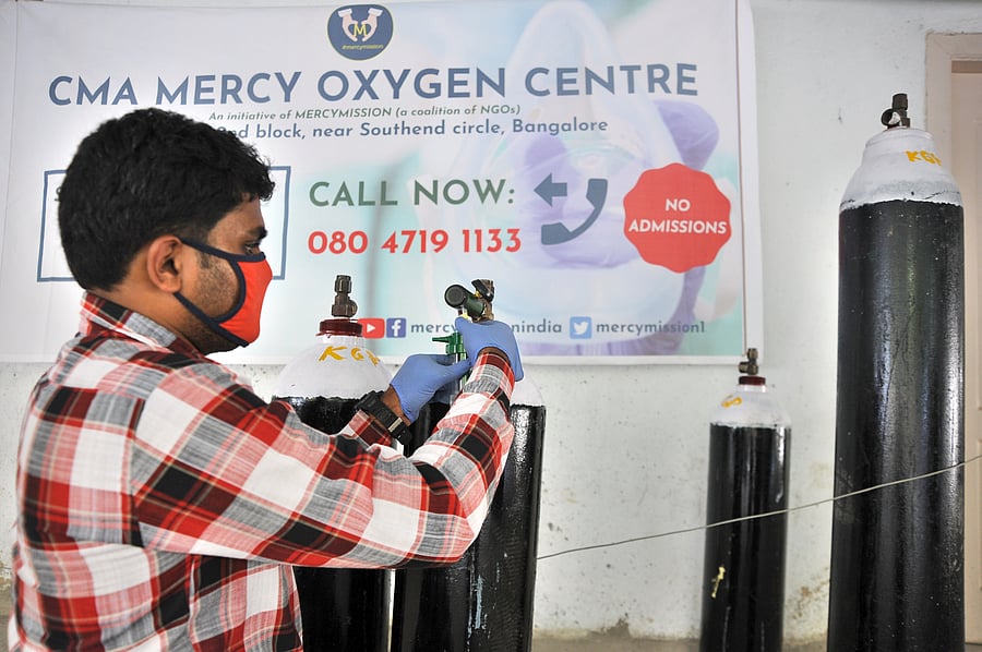 Arbaaz is being instructed on how to refill the humidifier as he bundles a cylinder for his father in the boot of his car. Credit: DH Photo