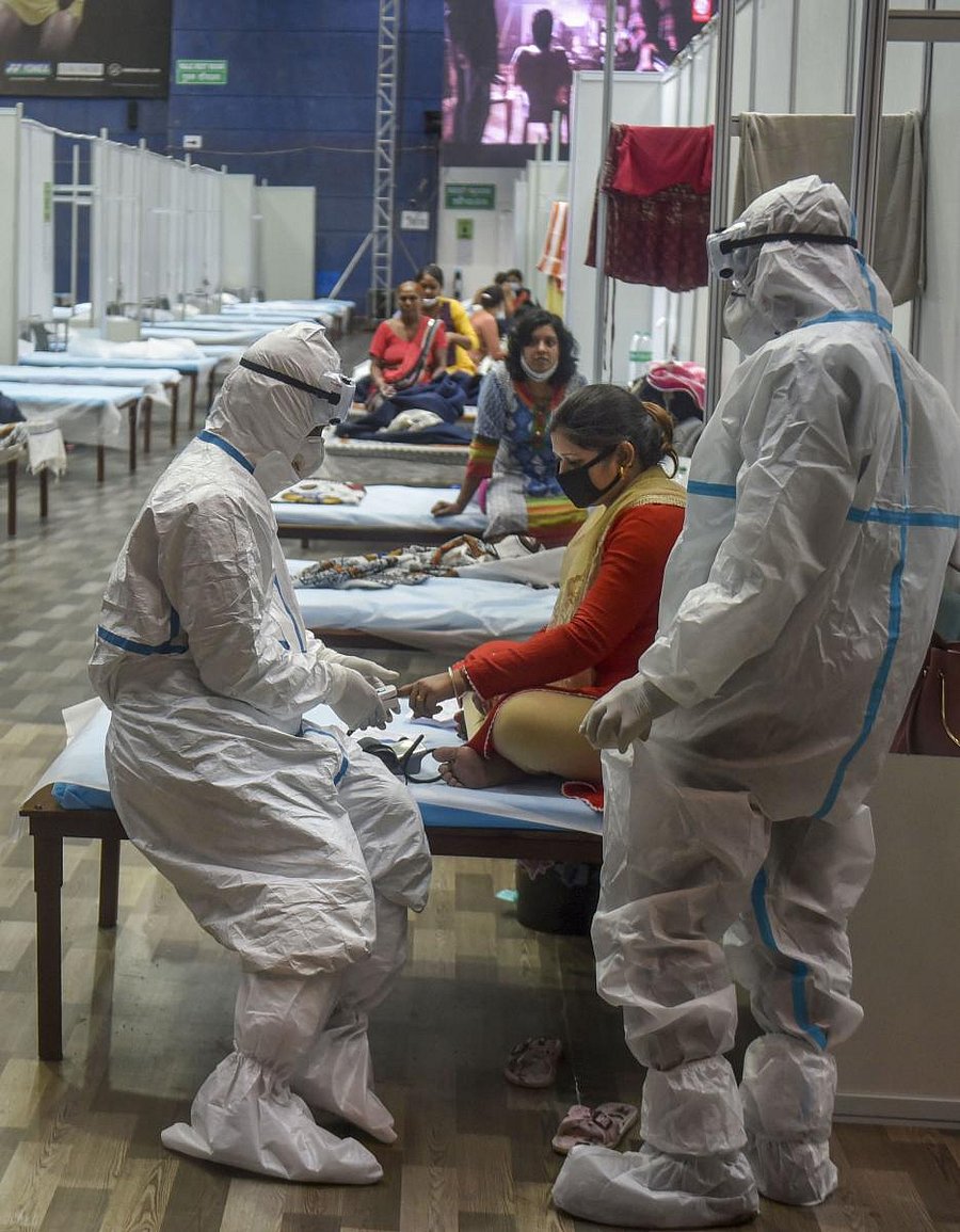 A medic checks a patient at CWG Village Covid-19 care centre during Unlock 2.0, near Akshardham in New Delhi (PTI Photo)