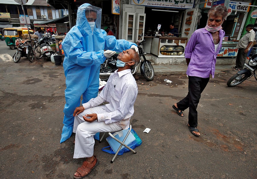 A healthcare worker takes a swab from a man in Ahmedabad.Credit: Reuters file photo