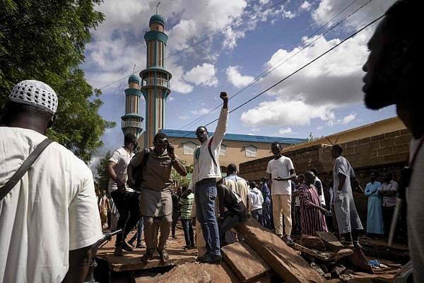 Protesters gestures on a barricade put up in front of the Salam mosque of Badalabougou. Credit: AFP
