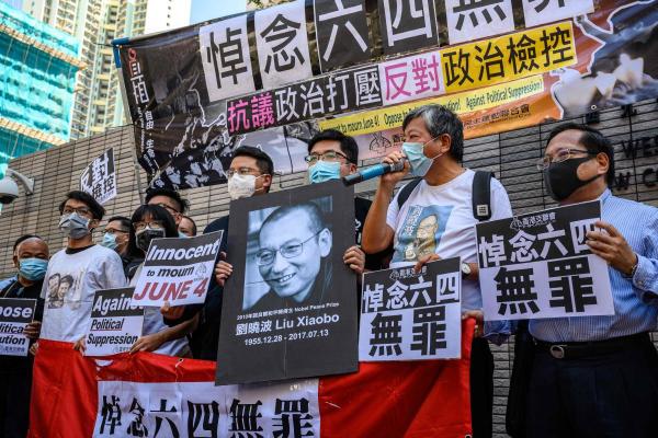 Supporters and activists, who led the June 4 candlelight vigil which commemorates the 1989 Tiananmen Square crackdown in Beijing, shout slogans before attending a mention at the West Kowloon Magistrates Court in Hong Kong on July 13, 2020. Credit: AFP Photo