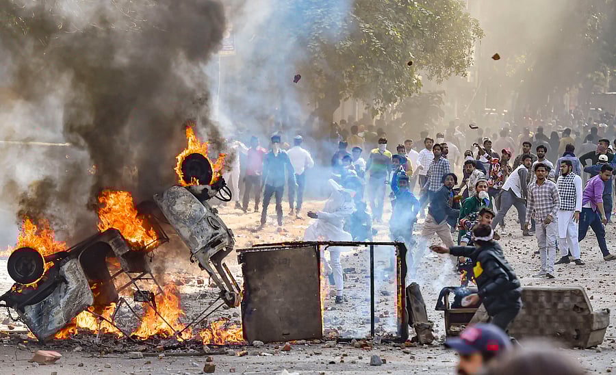 Vehicles set ablaze as protestors throw brick-bats during clashes between a group of anti-CAA protestors and supporters of the new citizenship act, at Jafrabad in north-east Delhi, Monday, Feb. 24, 2020. Credit: PTI Photo