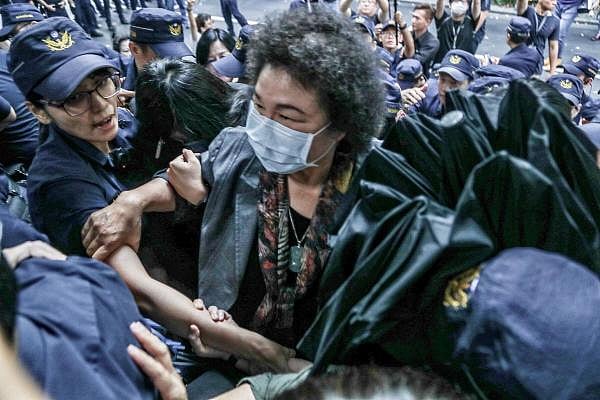 Chen Chu (C), former secretary general of the presidential office, being helped by police to get into the parliament after Taiwan's President Tsai Ing-wen nominated her as chairwoman of the country’s watchdog body in Taipei. Credit: AFP Photo