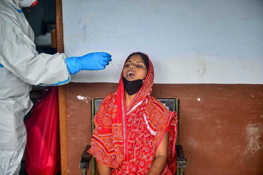 A health official takes a swab sample from a woman getting tested for the COVID-19 coronavirus, at a testing point in Allahabad. Credits: AFP Photo
