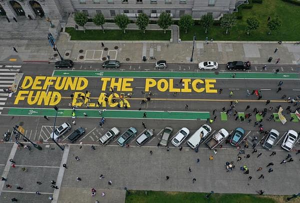 Protesters paint a mural that says 'defund the police' during a Strike For Black Lives demonstration outside of San Francisco City Hall. Credit: AFP Photo