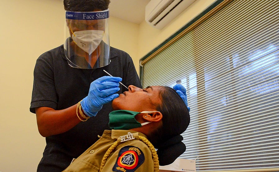 Navi Mumbai Municipal Corporation (NMMC) doctor collects swab sample of police personnel for COVID-19 Rapid Antigen Test at Navi Mumbai Police Headquarters. Credits: PTI Photo