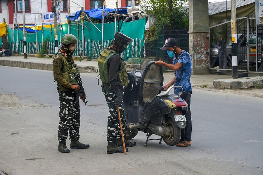 Security personnel stop vehicles for checking after an encounter with militants, on the outskirts of Srinagar. Credit: PTI