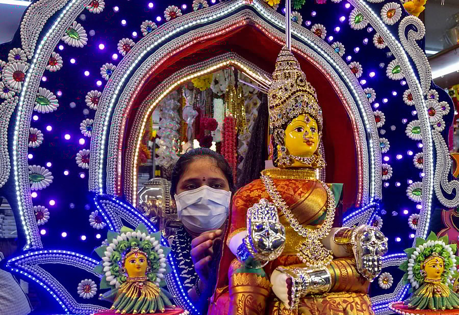 A shopkeeper (C) arranges an idol of Goddess Lakshmi for display on the eve of 'Vara Mahalakshmi Vratha', a Hindu ritual held to appease the Goddess of wealth and prosperity Lakshmi, in Bangalore on July 30, 2020. - The ritual is celebrated by Hindus in South India as a festival on the first Friday in the month of 'Shravana' according to the Hindu calendar on July 31. Credit: AFP