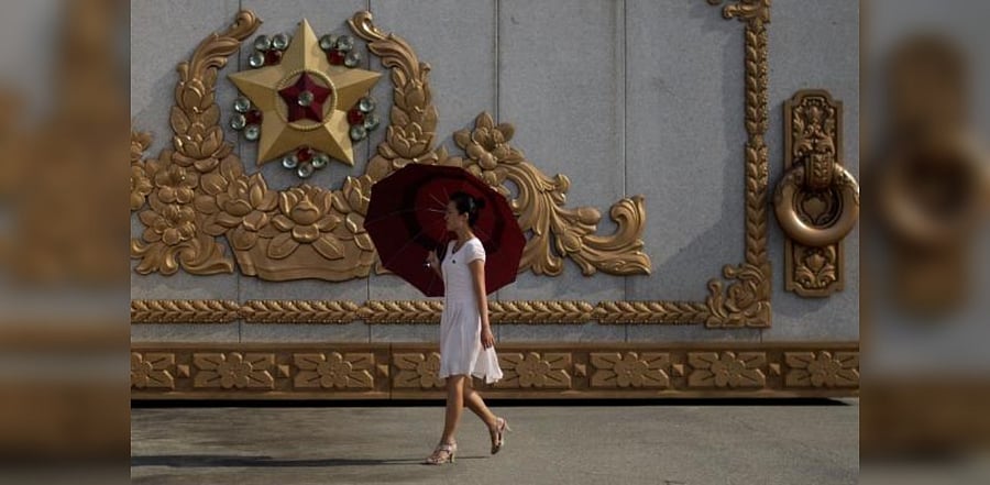 A North Korean woman walks past a gate of the Kumsusan Palace of the Sun mausoleum in Pyongyang. Representative Photo. Credit: AFP