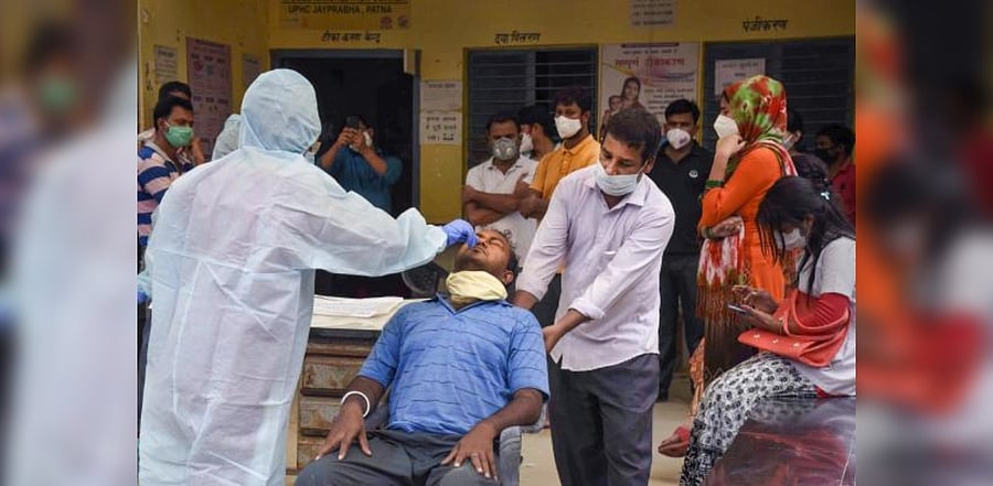 A medic takes samples from a man for Covid-19 testing at a camp. Credit: PTI Photo