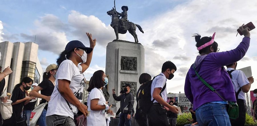 Protesters run around the King Taksin memorial during a Hamtaro-themed anti-government rally in Bangkok. Credit: AFP
