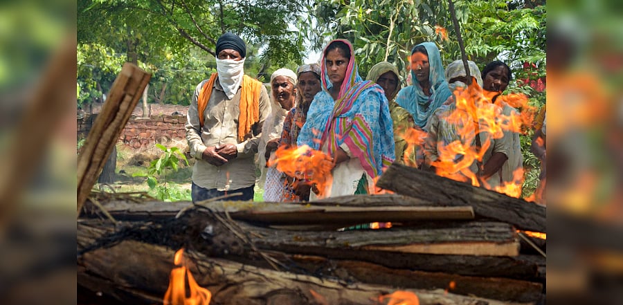 Family members and relatives attend the cremation of Kirpal Singh, who died after allegedly consuming spurious liquor, at Mucchal village near Amritsar. Credits: PTI Photo