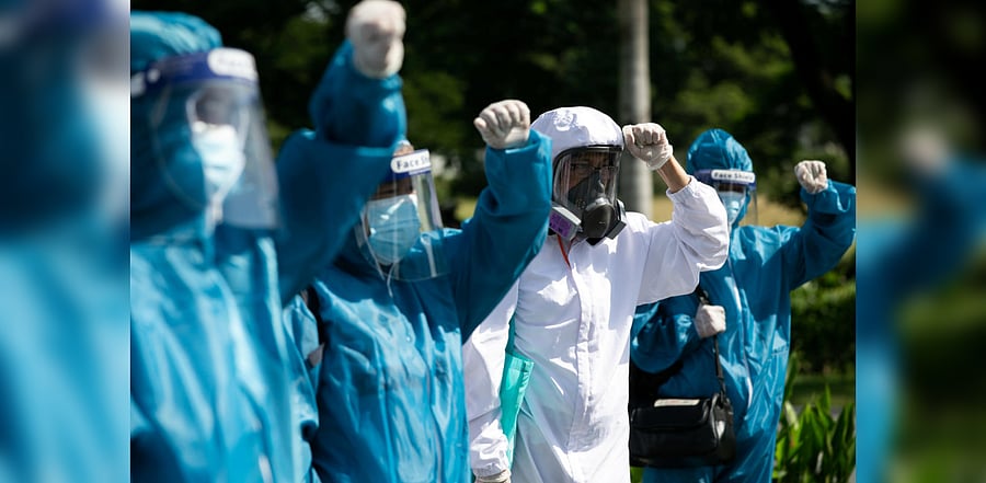 Healthworkers in hazmat suits join the protest ahead of Philippine President Rodrigo Duterte. Credit: Reuters