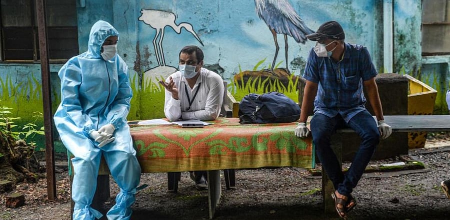 Health workers and civic staff wait for students at the Children Aid Society premises during a medical screening for the COVID-19 coronavirus, in Mumbai. (AFP)