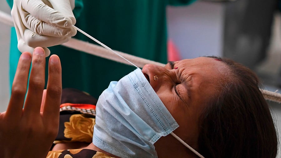 A medical staff collects a nasal swab of a woman with a Rapid Antigen Test (RAT) kit for the Covid-19. Credits: AFP Photo