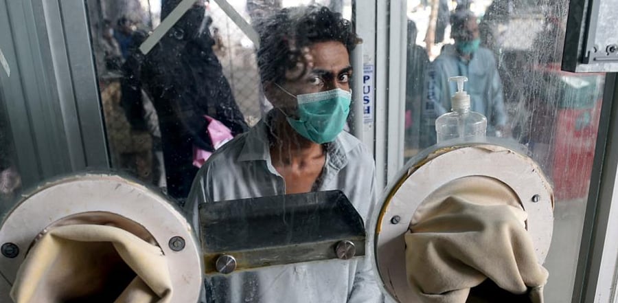 A man waits for a health worker to take a swab sample to test for the Covid-19. Credit: AFP
