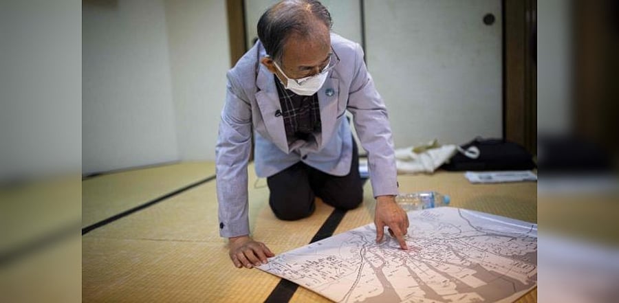 Jiro Hamasumi, whose mother was pregnant with him in Hiroshima when the atomic bomb struck in 1945, points at the hypocentre of the bombing and the Hiroshima Peace Memorial. Credit: AFP