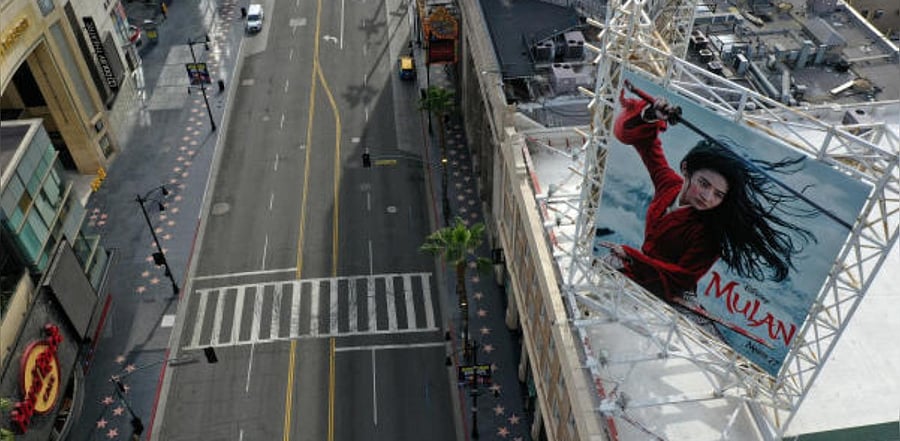 A poster of the Walt Disney Studios' "Mulan" movie, which was going to be released on March 27, towers over an empty Hollywood Boulevard during the global outbreak of coronavirus disease. Credit: Reuters