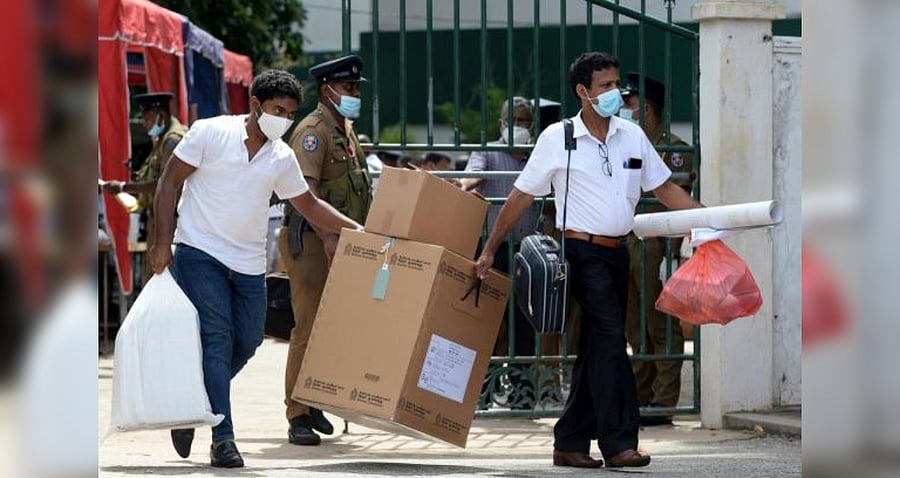 Electoral officials collect ballot papers and boxes from a distribution centre for their respective polling stations on the eve of the parliamentary elections in Colombo. Credit: AFP