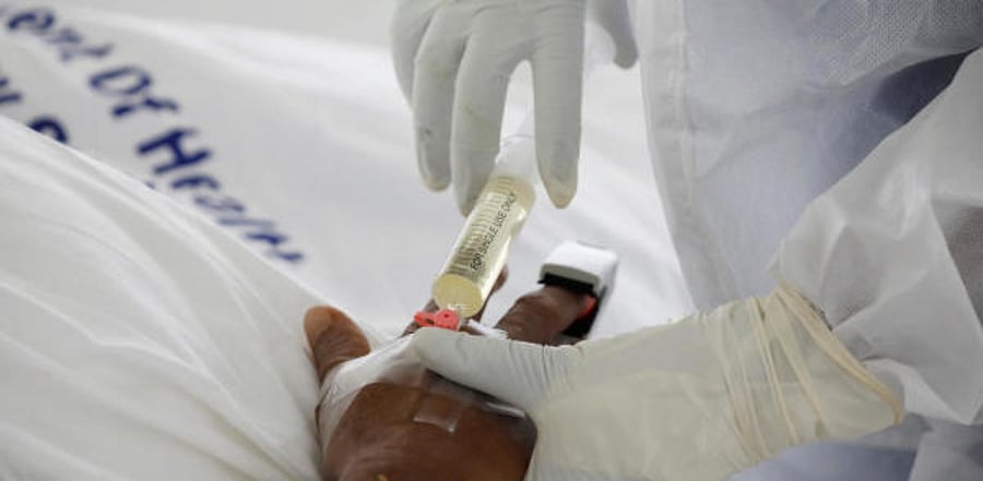 A nurse uses a syringe to give an injection to a Covid-19 patient. Credit: Reuters