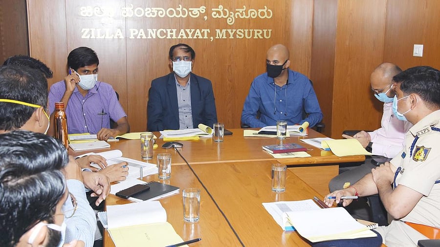 District In-charge Secretary Jayaram chairs a meeting at Zilla Panchayat office in Mysuru on Friday. Deputy Commissioner Abhiram G Sankar and Superintendent of Police C B Ryshyanth are seen. DH PHOTO