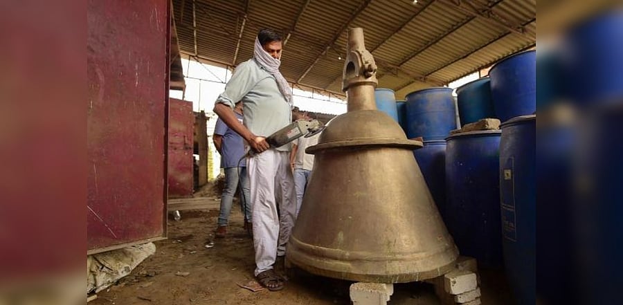 Craftsman Dau Dayal works on a bell, weighing 2,100 kilograms for the Ram temple in Ayodhya, at a workshop. Credit: PTI