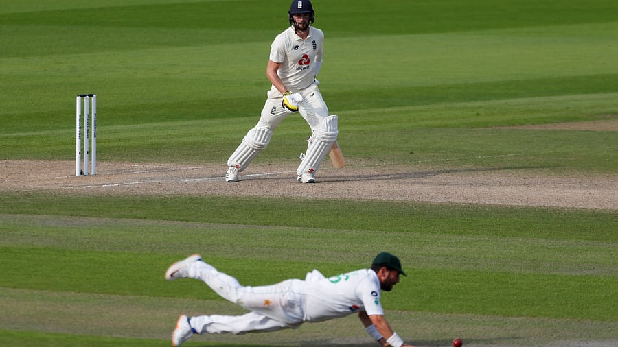 England's Chris Woakes in action as Pakistan's Yasir Shah dives for the ball, as play resumes behind closed doors following the outbreak of the coronavirus disease. Credits: Reuters Photo
