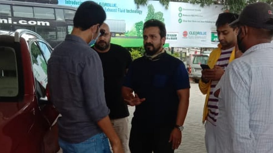 The actor interacts with fuel station owner in Shivamogga. Credits: DH Photo