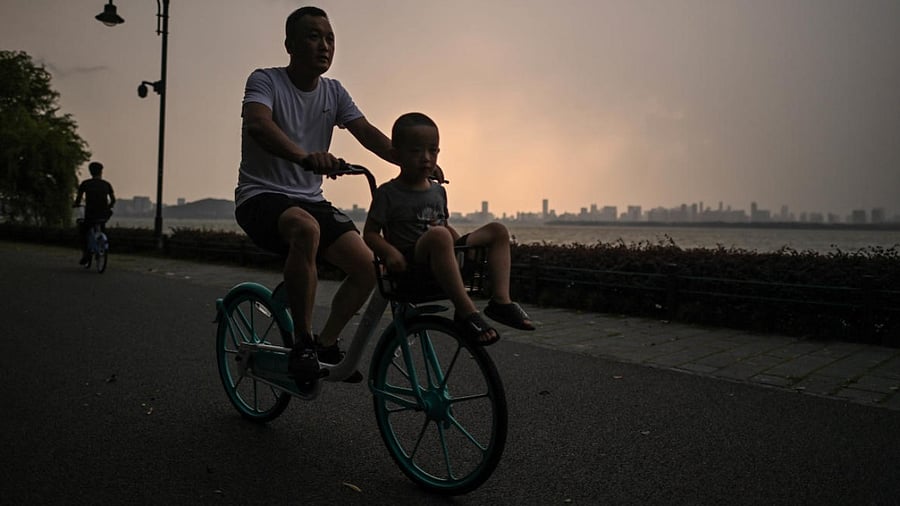 This photo taken on August 5, 2020 shows a man riding a bicycle along East Lake in Wuhan in China’s central Hubei province. Credit: AFP