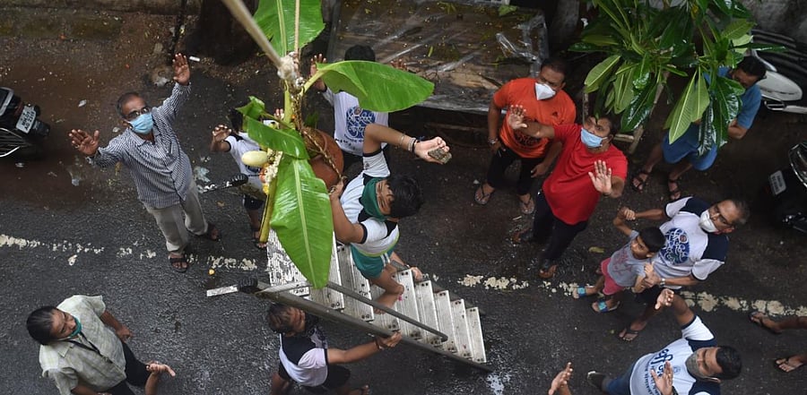 A Hindu devotee tries to break a dahi-handi (curd-pot) suspended in the air from atop a ladder during 'Janmashtami' festival celebrations marking the birth of Hindu God Lord Krishna, in Mumbai. Credit: AFP Photo