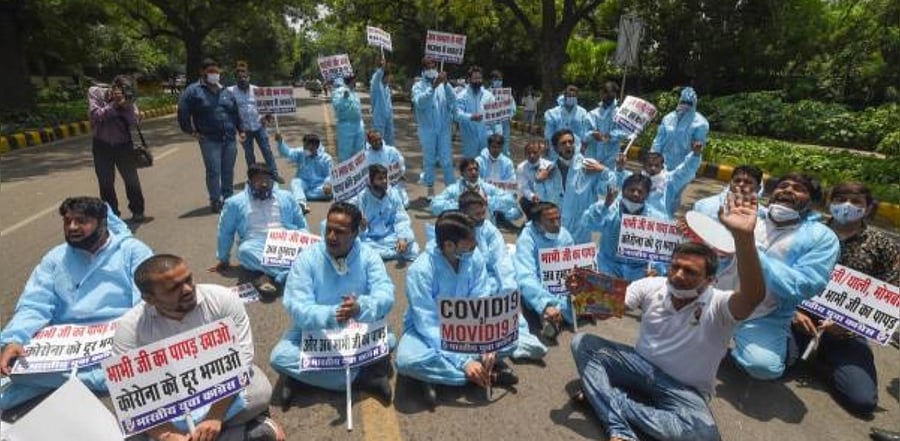 Indian Youth Congress activists wearing PPE kits stage a protest against the Central Government on the surge in Covid-19 cases across the country, in New Delhi. Credit: PTI Photo
