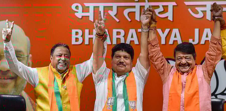 Former TMC leader Arjun Singh joins hands with BJP senior leaders Kailash Vijayvargiya and Mukul Roy after joining Bharatiya Janata Party. Credit: PTI Photo