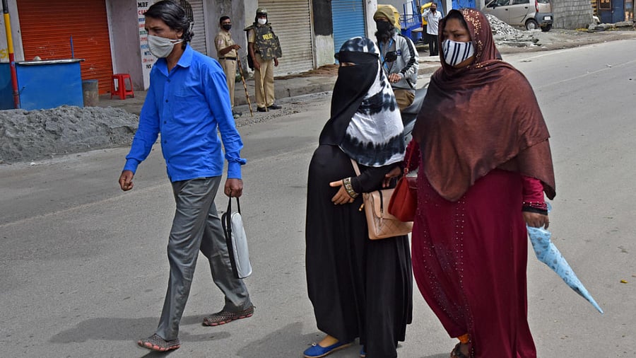People walk on a deserted road. Credits: DH Photo