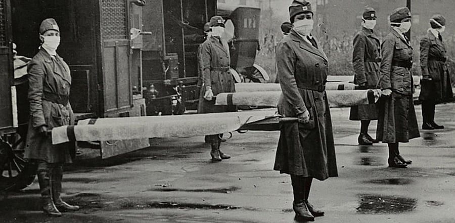 Mask-wearing women hold stretchers near ambulances during the Spanish Flu pandemic in St. Louis, Missouri, U.S. in October 1918. Library of Congress/Handout via Reuters