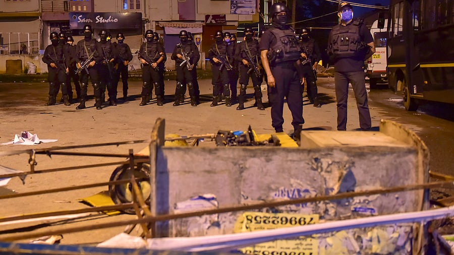 A special police force team 'Garudu' deployed at the site of violence after a mob vandalised a police station and burnt vehicles over a social media post by a relative of a MLA, in Bengaluru. Credits: PTI Photo
