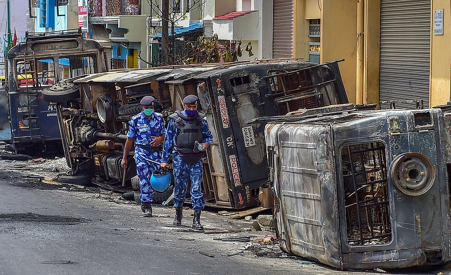 Rapid Action Force (RAF) personnel carry out a flag march in the riot-hit area after a mob went on a rampage. Credit: PTI
