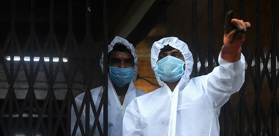 Crematory Operators wearing personal protective equipment (PPE) wait for the body of a person who died of Covid-19, for a cremation, outside the Nimtala Crematorium, in Kolkata on August 17, 2020. Credit: AFP Photo