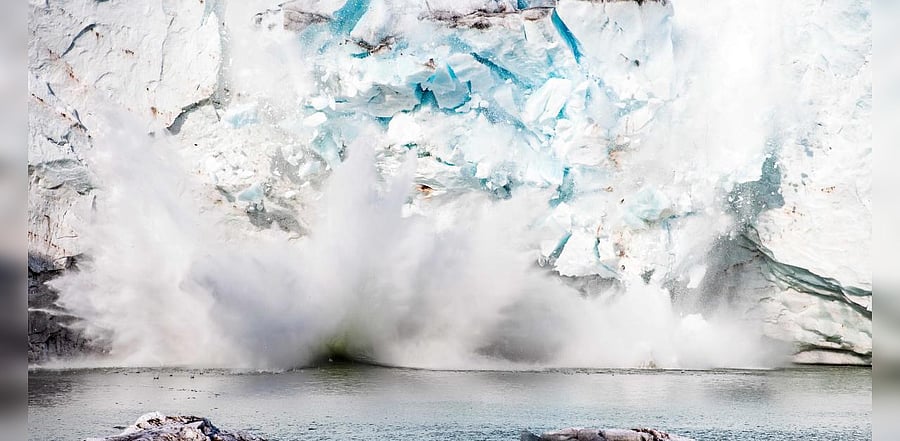 An iceberg calving with a mass of ice breaking away from the Apusiajik glacier, near Kulusuk, on the southeastern shore of Greenland. Credits: AFP