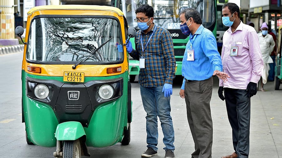 BBMP officials urge an auto driver to get tested for Covid-19 in Vijayanagar. DH Photo/Ranju P