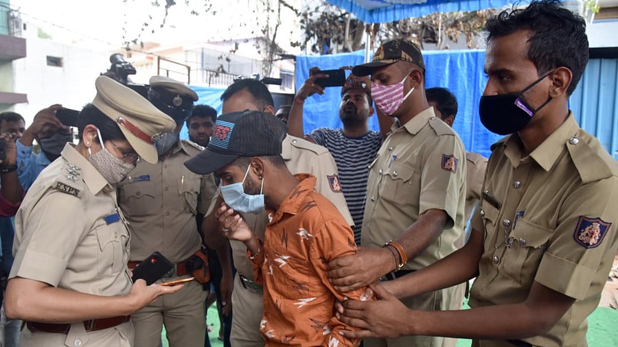 Police detained a man who was making videos of the violence-hit Kaval Byrasandra, Bengaluru, on Monday. DH PHOTO/S K DINESH