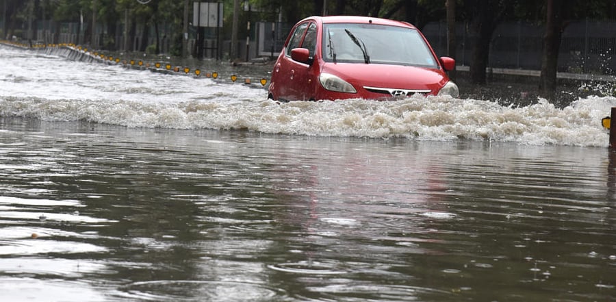 Vehicle movement is difficult in stagnated rainwater due to heavy rain. Credit: DH Photo